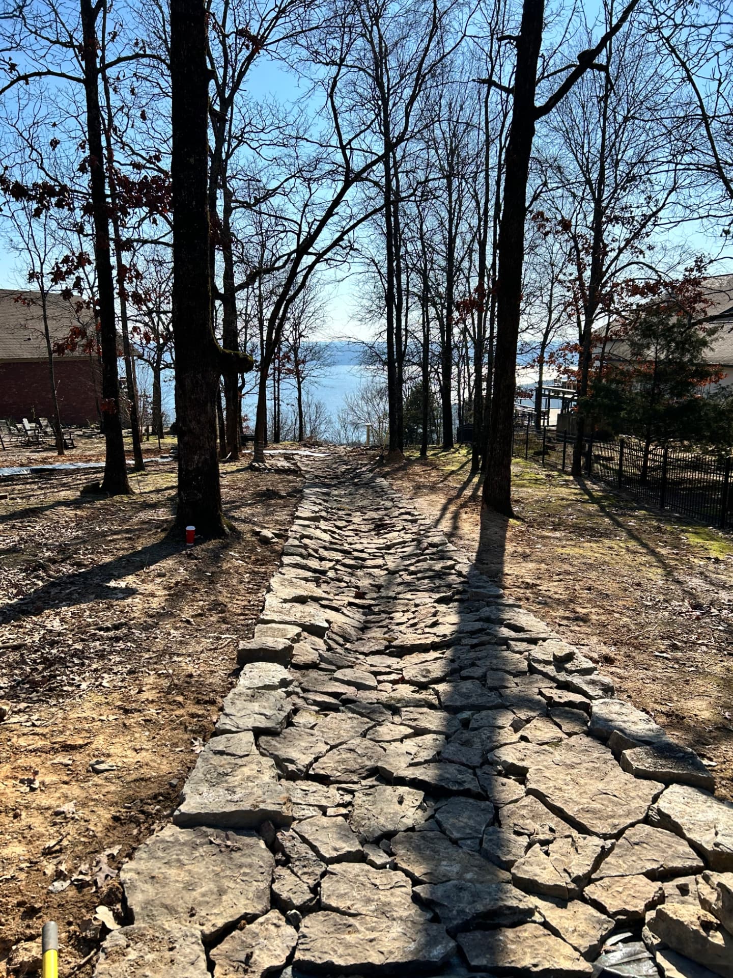Finished dry-laid stone drainage swale running downhill toward Greers Ferry Lake in Arkansas