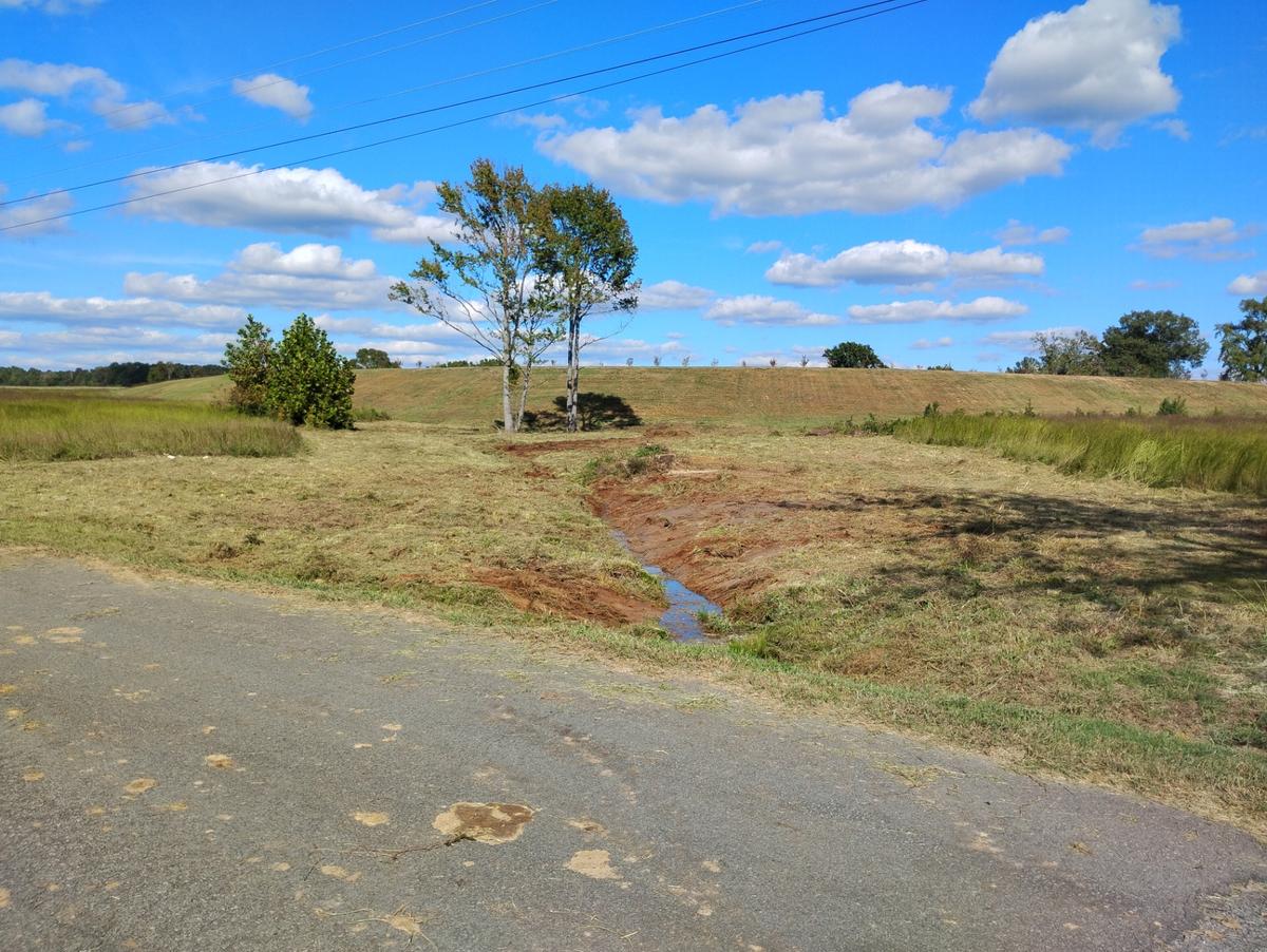 Cleared field with a freshly reshaped drainage ditch running to the road after land clearing in Higden, Arkansas