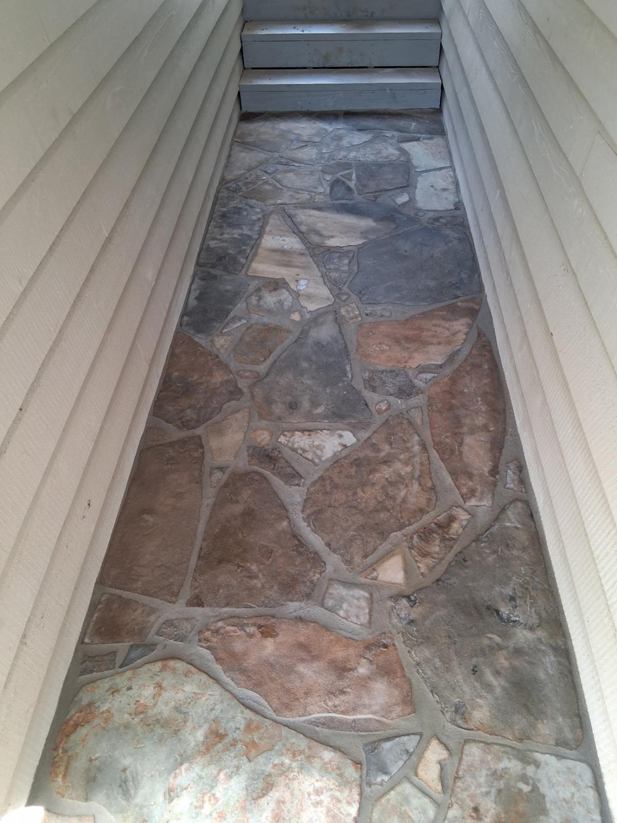Finished irregular flagstone walkway between two house walls in Greers Ferry, Arkansas