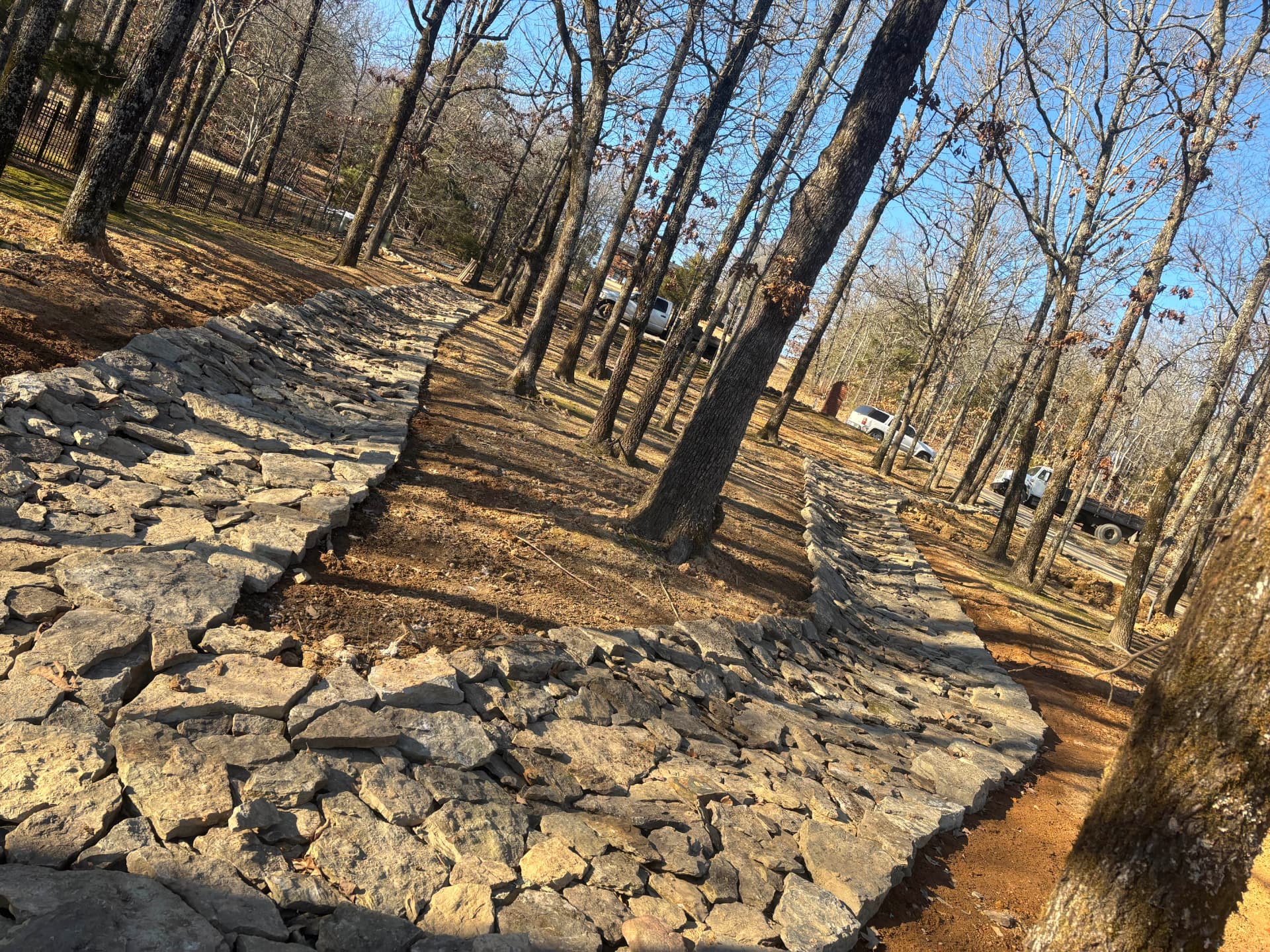 Stone-lined channel winding through the trees to carry runoff away.
