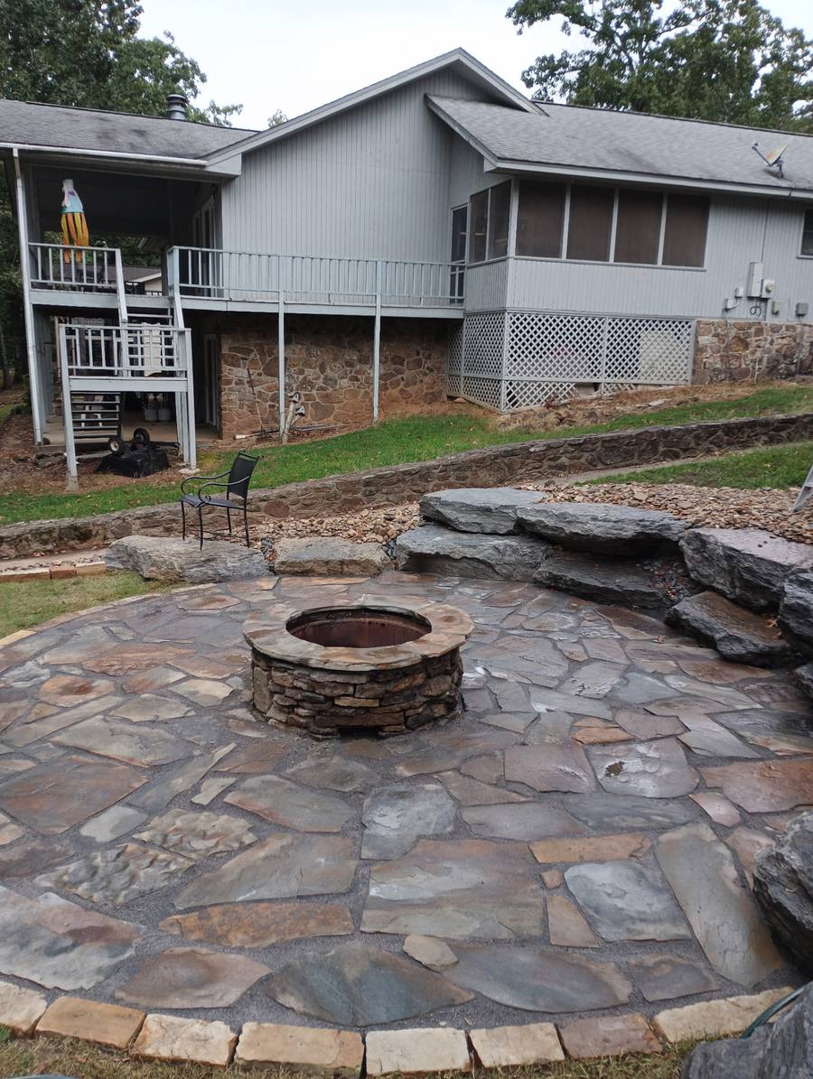 Round flagstone patio built around a stacked stone fire pit.